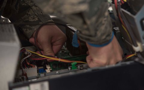 Technician installing memory module into laptop RAM slot hardware upgrade procedure Technician installing memory module into laptop RAM slot hardware upgrade procedure
