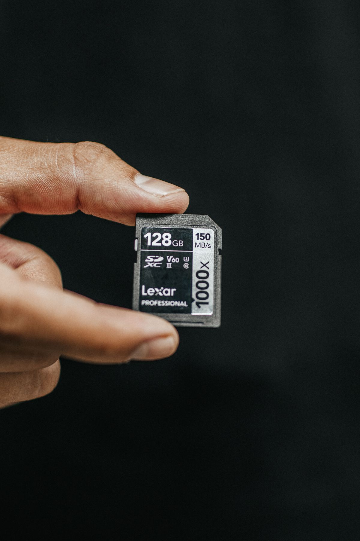 Person holding SD memory card used for Imou camera local storage troubleshooting Person holding SD memory card used for Imou camera local storage troubleshooting