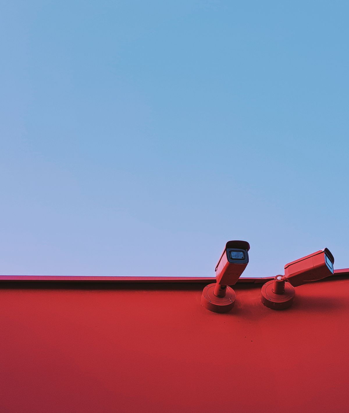 Two red toned security cameras illustrating red light indicator on camera Two red toned security cameras illustrating red light indicator on camera